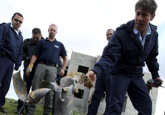 Izraelski policist pregleduje ostanke granate.